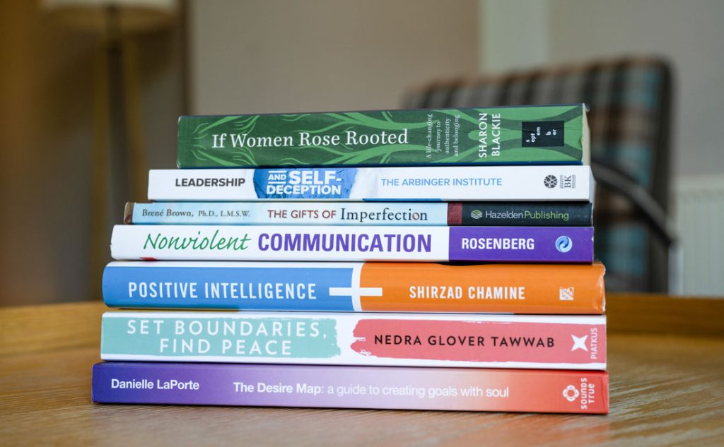 Stack of books about topics such as leadership and emotional intelligence